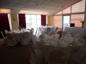 angled roof room with tables with white linens